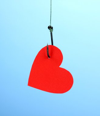 Heart on fish hook on blue background clipart