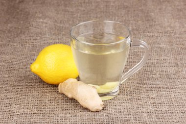 Healthy ginger tea with lemon on sackcloth clipart