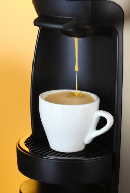 Espresso makinesi kahve fincanına kahve dolduruyor.