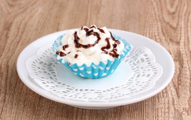 ahşap zemin üzerinde uçan daire üzerinde kremalı cupcake