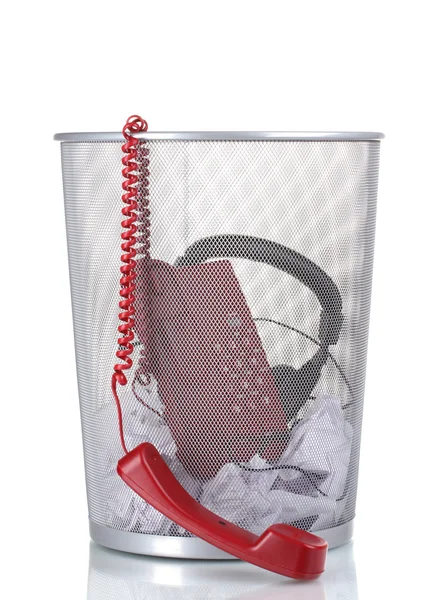 Красный телефон, наушники и бумага в металлическом мусорном ведре изолированы на белом — стоковое фото