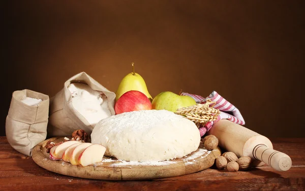 Ингредиенты для домашнего пирога на деревянном столе на коричневом фоне — стоковое фото