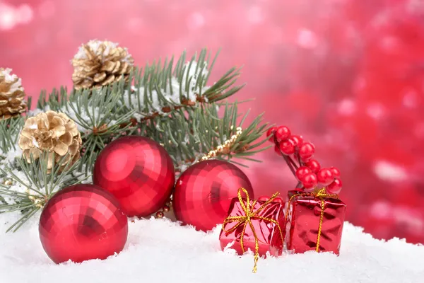 Weihnachtskugel und grüner Baum im Schnee auf rot — Stockfoto