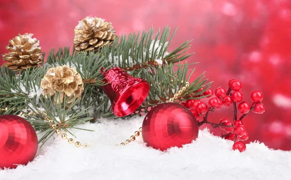 Vánoční koule a zelený strom na sněhu na červené — Stock fotografie