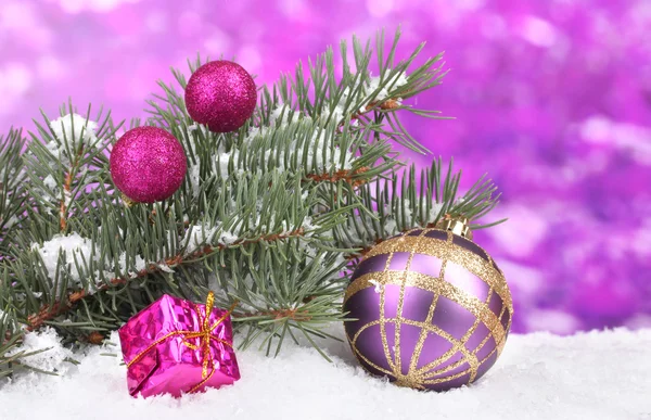 Karácsonyi labda és játékszer zöld fa a hóban, a lila — Stock Fotó