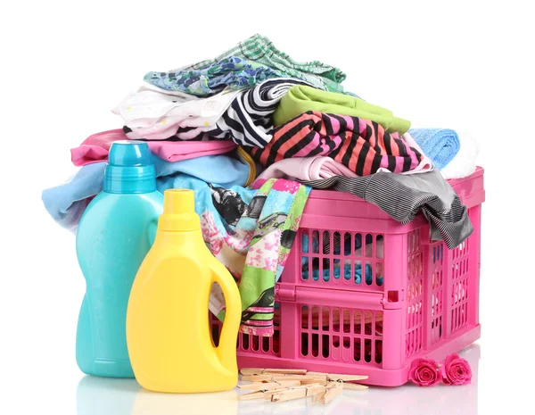 Kläder med tvättmedel i rosa plast korg isolerad på vit — Stockfoto