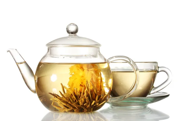 Exotic green tea with flowers in glass teapot and cup isolated on white — Stock Photo, Image
