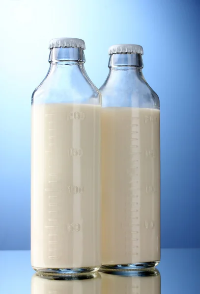 Flaschen Milch auf blauem Hintergrund — Stockfoto