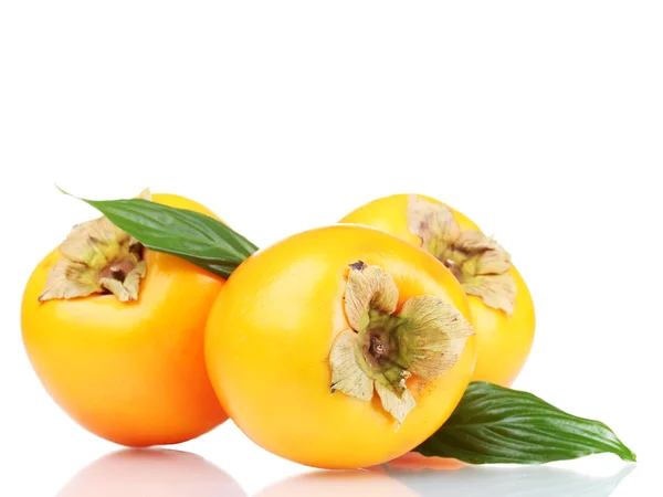 Three appetizing persimmons with green leaves isolated on white — Stock Photo, Image