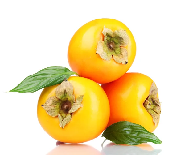 Tre appetitvækkende persimmons med grønne blade isoleret på hvid - Stock-foto