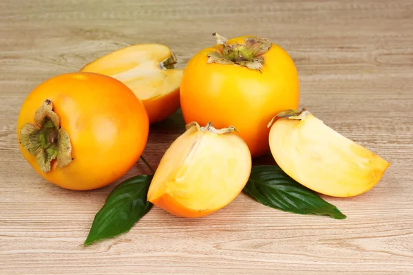 stock image Appetizing persimmons on wooden background