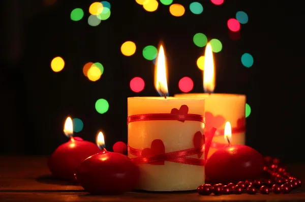 Hermosas velas sobre mesa de madera sobre fondo brillante — Foto de Stock