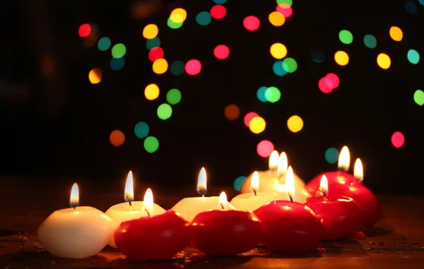 Belas velas na mesa de madeira no fundo brilhante — Fotografia de Stock