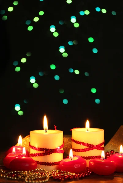 Piękne świece na drewnianym stole na jasnym tle — Zdjęcie stockowe