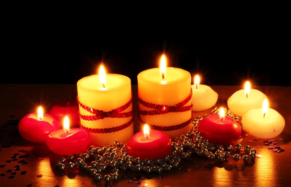 Belas velas e decoração em mesa de madeira sobre fundo preto — Fotografia de Stock