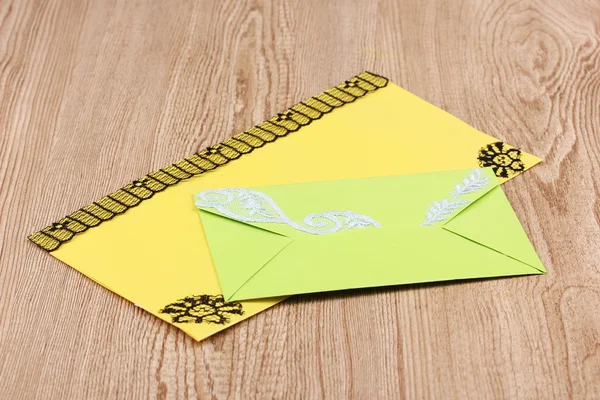 Envelopes de cor em fundo de madeira — Fotografia de Stock