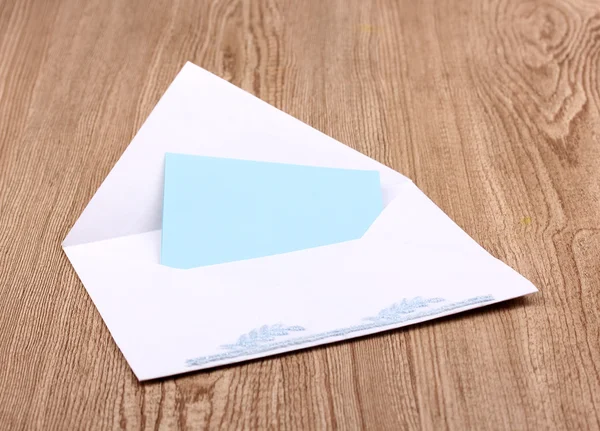 Білий конверт на дерев'яному фоні — стокове фото