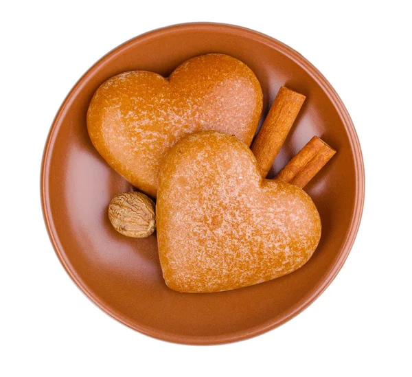 Hart-vormige cookies met kaneel en nootmuskaat op schotel geïsoleerd op wit — Stockfoto