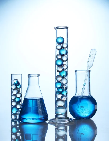 Tubes à essai avec liquide bleu sur fond bleu — Photo