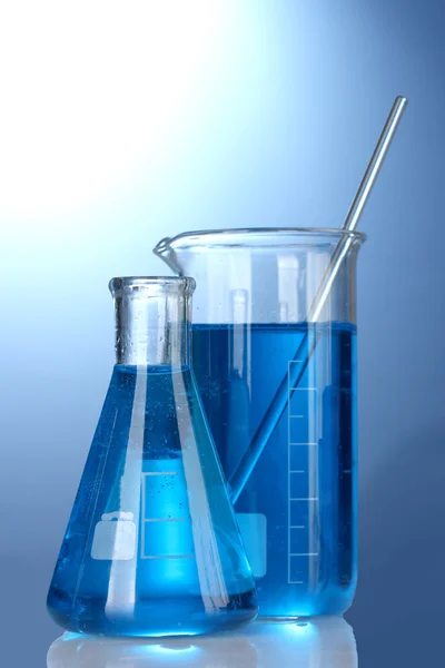 Test tüpleri mavi zemin üzerine mavi sıvı ile — Stok fotoğraf