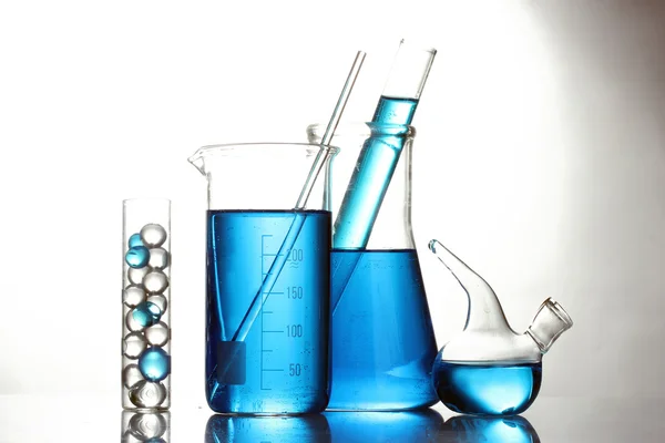Tubos de ensayo con líquido azul aislado sobre blanco — Foto de Stock