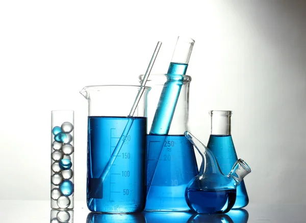 Test tüpleri üzerinde beyaz izole mavi sıvı ile — Stok fotoğraf