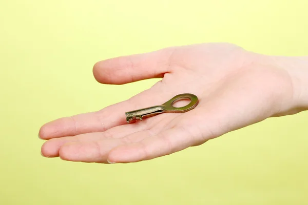 Key in hand on green background — Stock Photo, Image