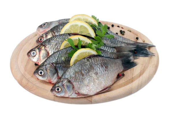 Φρέσκα ψάρια με λεμόνι, μαϊντανό και καρύκευμα στο ξύλινο κοπή του σκάφους που απομονώνονται σε λευκό — Φωτογραφία Αρχείου