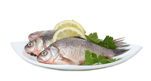 Ikan segar dengan lemon dan peterseli di piring terisolasi di atas putih — Stok Foto