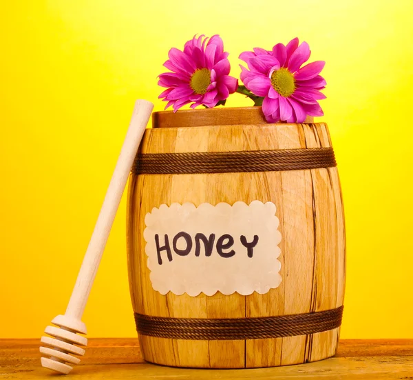 Zoete honing in vat met drizzler op houten tafel op gele achtergrond — Stockfoto