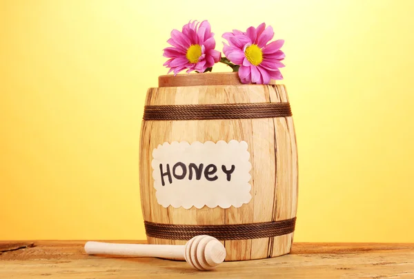 Söt honung i fat med drizzler på träbord på gul bakgrund — Stockfoto