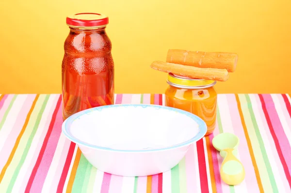 Jar of baby puree and juice with plate and spoon on napkin on blue background — Stock Photo, Image