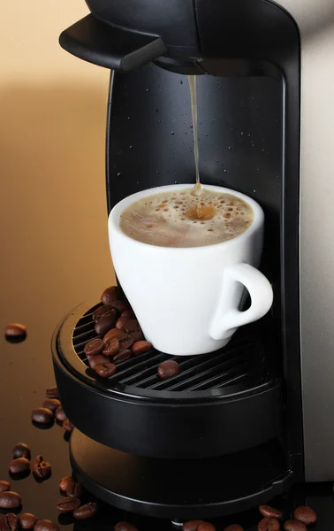 stock image Espresso machine pouring coffee in cup on brown background