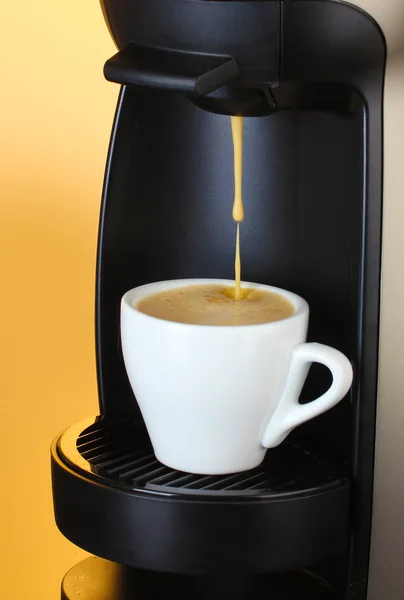 stock image Espresso machine pouring coffee in cup on brown background