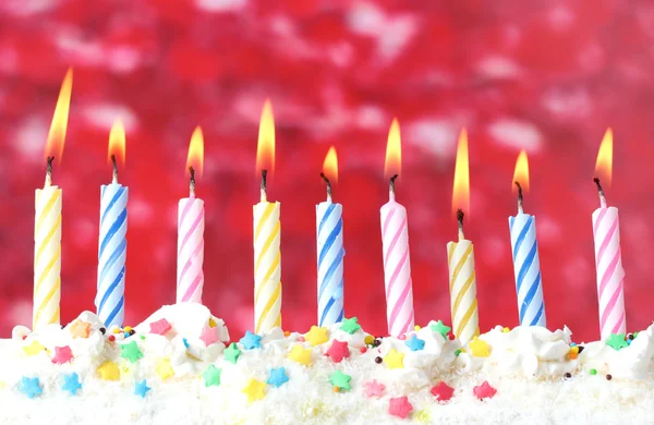 Hermosas velas de cumpleaños sobre fondo rojo — Foto de Stock