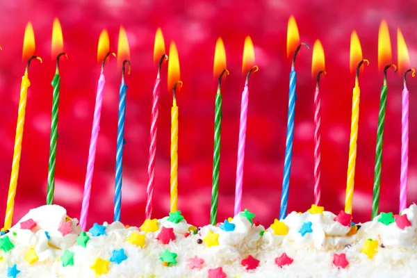 Belas velas de aniversário no fundo vermelho — Fotografia de Stock