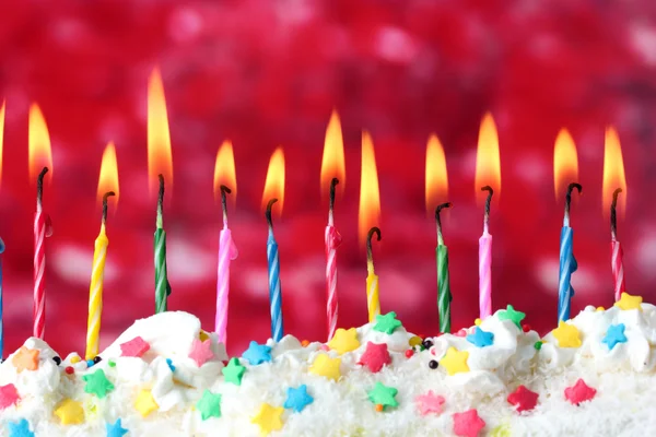 Hermosas velas de cumpleaños sobre fondo rojo — Foto de Stock