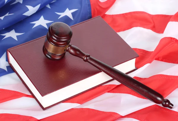 Soudce kladívkem a kniha na pozadí americké vlajky — Stock fotografie