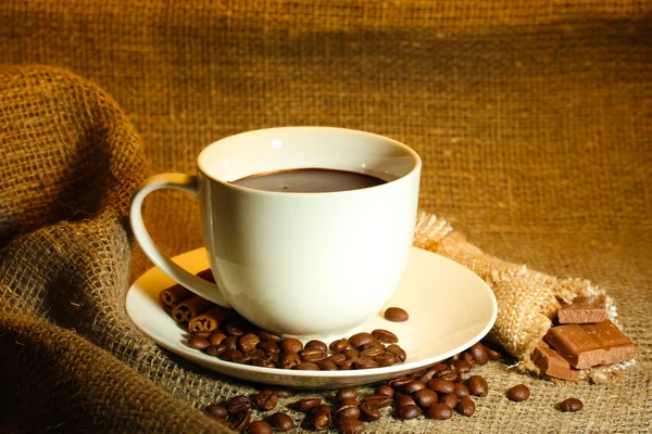 Kopp kaffe, bönor och choklad på sparka bakgrund — Stockfoto