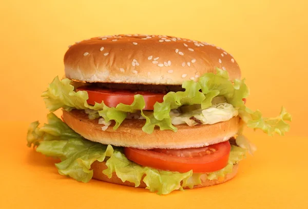 Big and tasty hamburger on yellow background — Stock Photo, Image