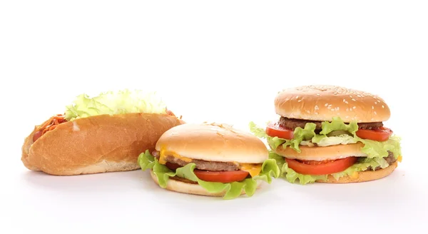 Sabrosas hamburguesas y perritos calientes aislados en blanco — Foto de Stock