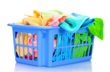 Plastic basket with bright towels isolated on white clipart