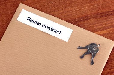 Rental contract on wooden background close-up clipart