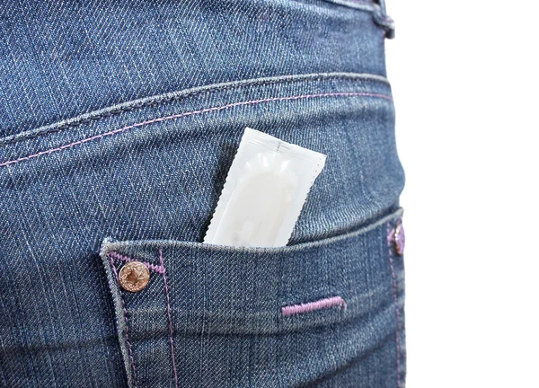 Preservativo nella tasca di jeans blu su bianco — Foto Stock