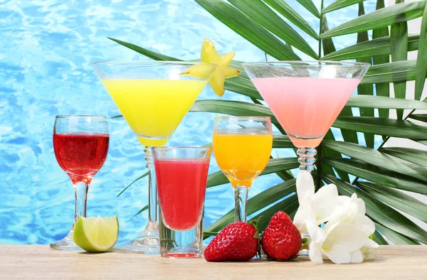 Exotische cocktails en bloemen op tafel op blauwe zee achtergrond — Stockfoto
