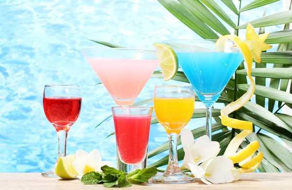 Экзотические коктейли и цветы на синем фоне — стоковое фото