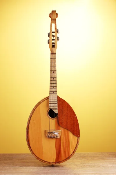 Ретро-кобза - украинский музыкальный инструмент на деревянном столе на желтом фоне — стоковое фото