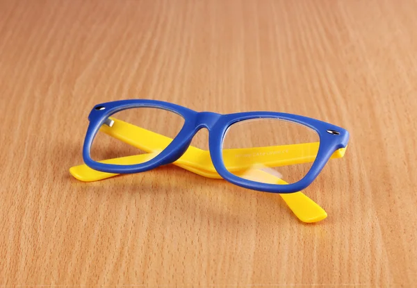 Mooie kleur bril op houten achtergrond — Stockfoto