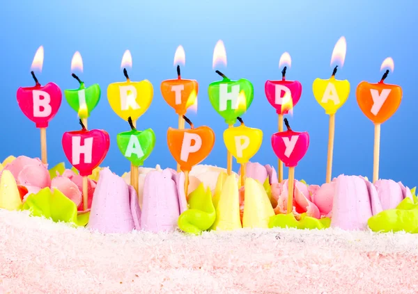 Торт на день народження зі свічками на синьому фоні — стокове фото