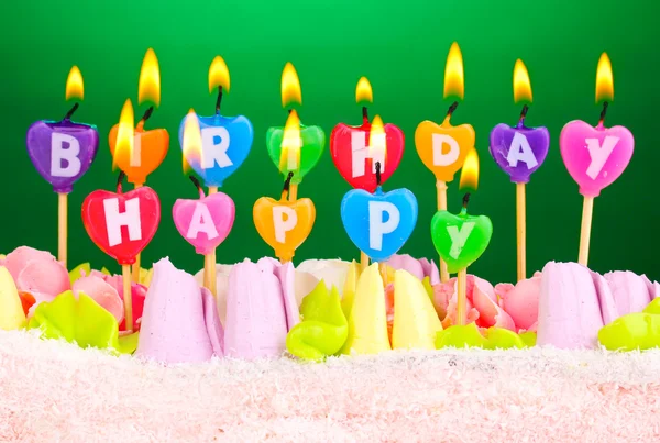 Торт на день народження зі свічками на зеленому фоні — стокове фото